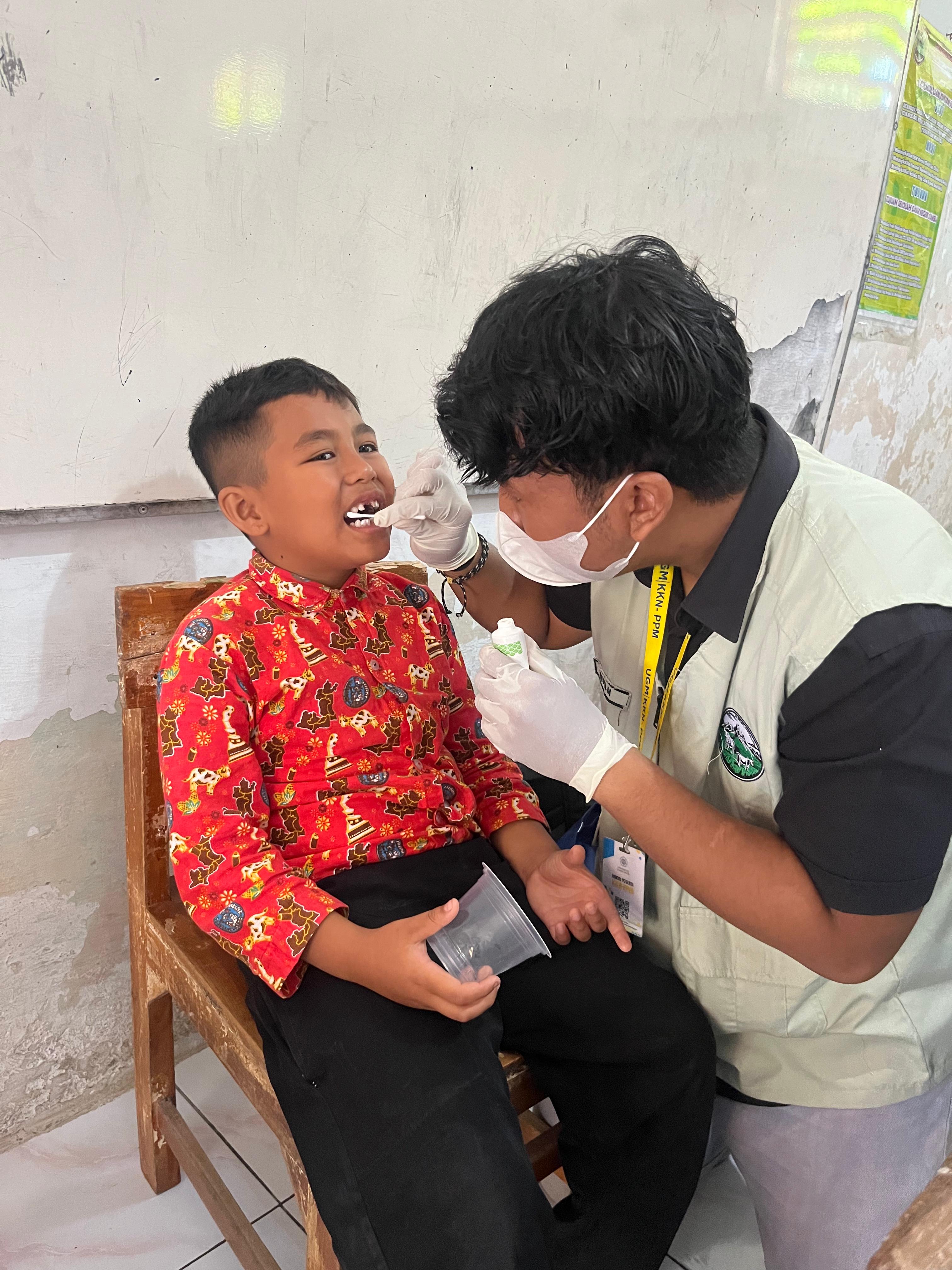 pemberian topical fluoride kepada siswa-siswi SDN 2 Tambak | Foto: Dokumentasi Pribadi/Tim KKN-PPM UGM Mojosongo Makaryo
