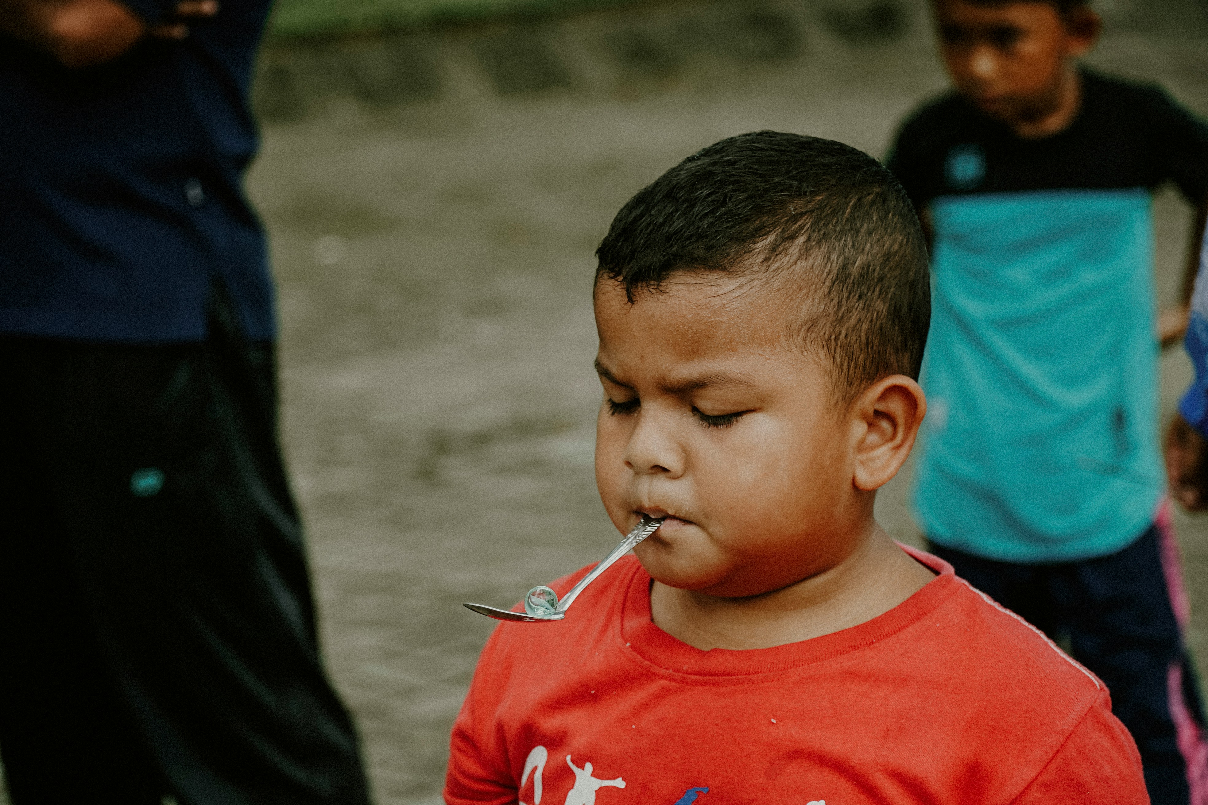 Seorang anak membawa kelereng dengan sendok