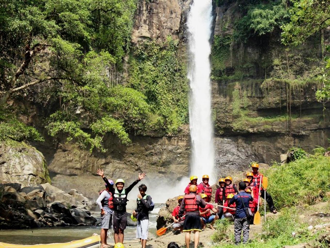 Tampak pengunjung yang bersiap untuk rafting dengan latar belakang foto Air Terjun Coban Baung