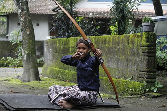 gambar anak kecil Jawa sedang bermain jemparingan