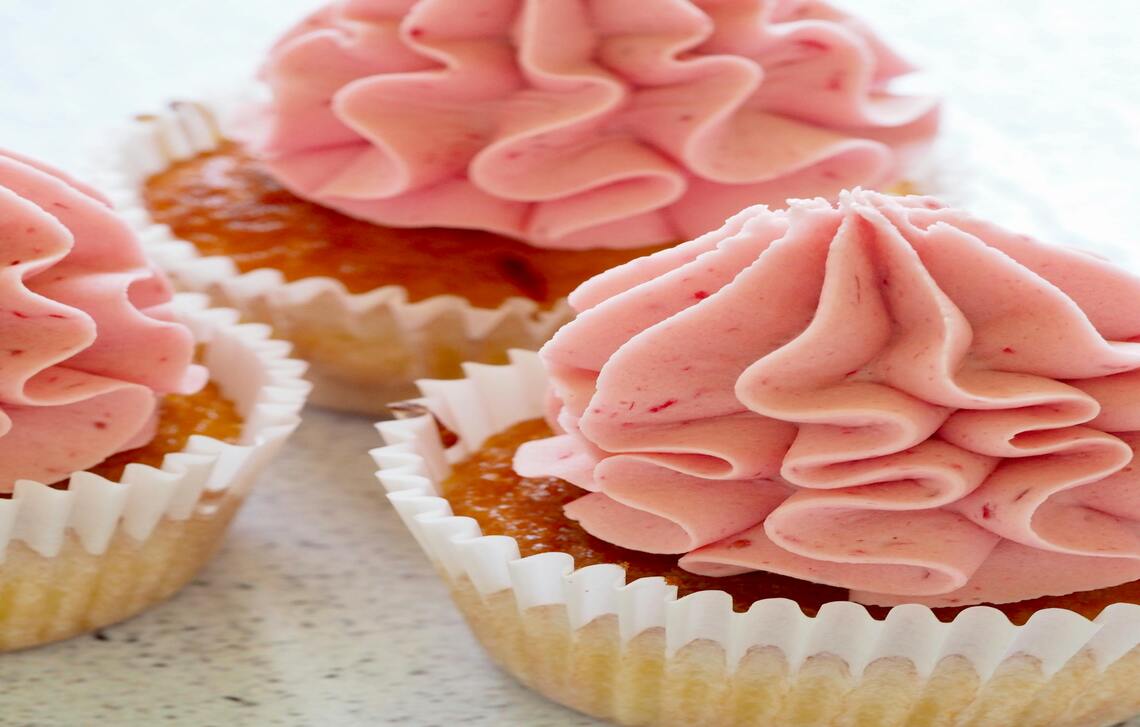 Cupcake dengan atasan krim berwarna pink.