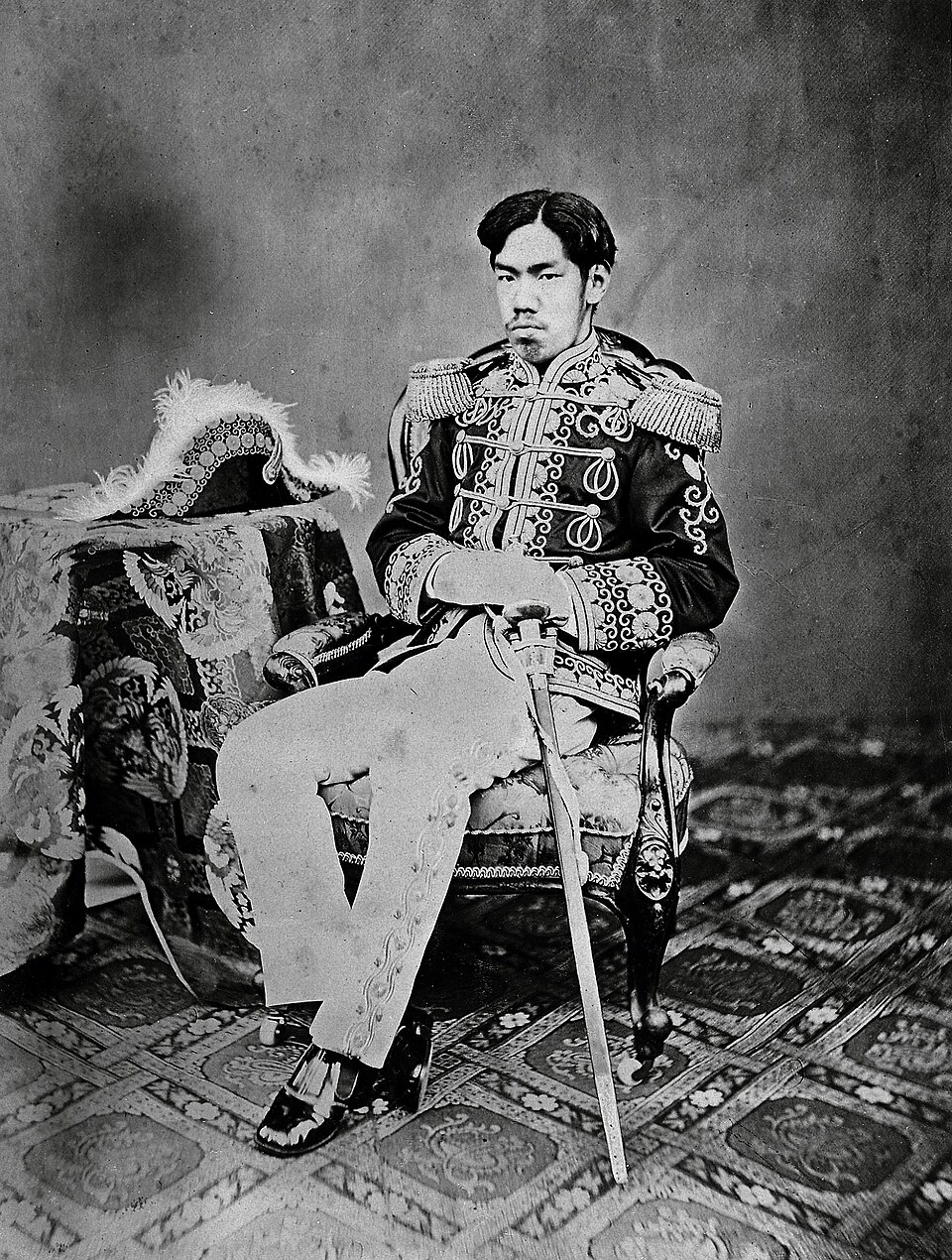 Potret resmi Kaisar Meiji pada masa awal modernisasi Jepang. Setelah tekanan dari kedatangan armada Komodor Perry di Teluk Edo tahun 1853, Kaisar Meiji memimpin transformasi besar-besaran dalam sistem militer, pendidikan, dan industri Jepang. Mengenakan seragam militer ala Barat, sang Kaisar menjadi lambang perubahan: dari negara tertutup yang tak siap menghadapi dunia, menjadi kekuatan modern yang disegani.(Sumber: The Cleveland Museum of Art / Kinoshita, 1873)
