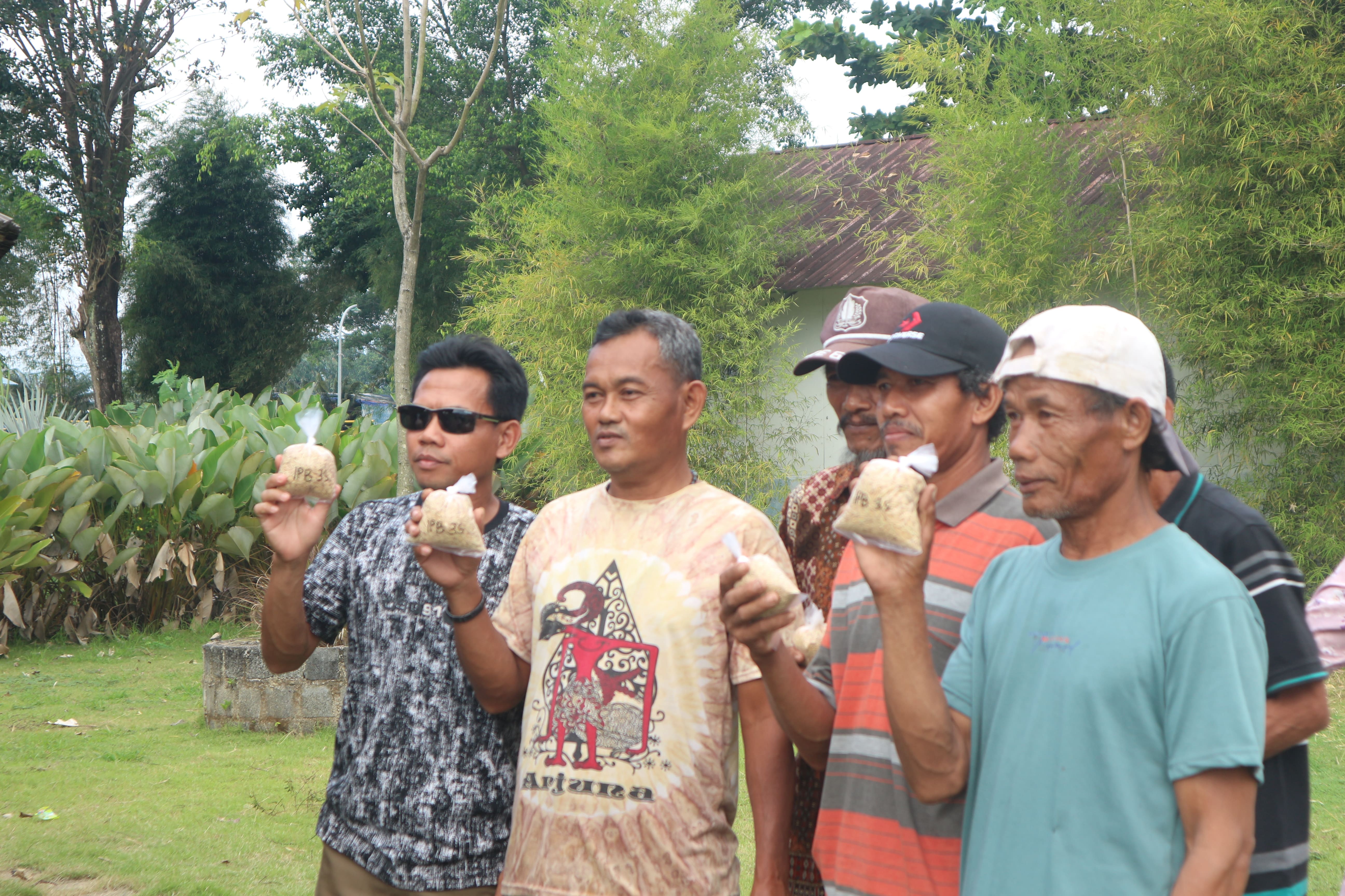 Para petani Desa Brondong menunjukkan antusiasmenya setelah menerima benih padi unggul dari program 