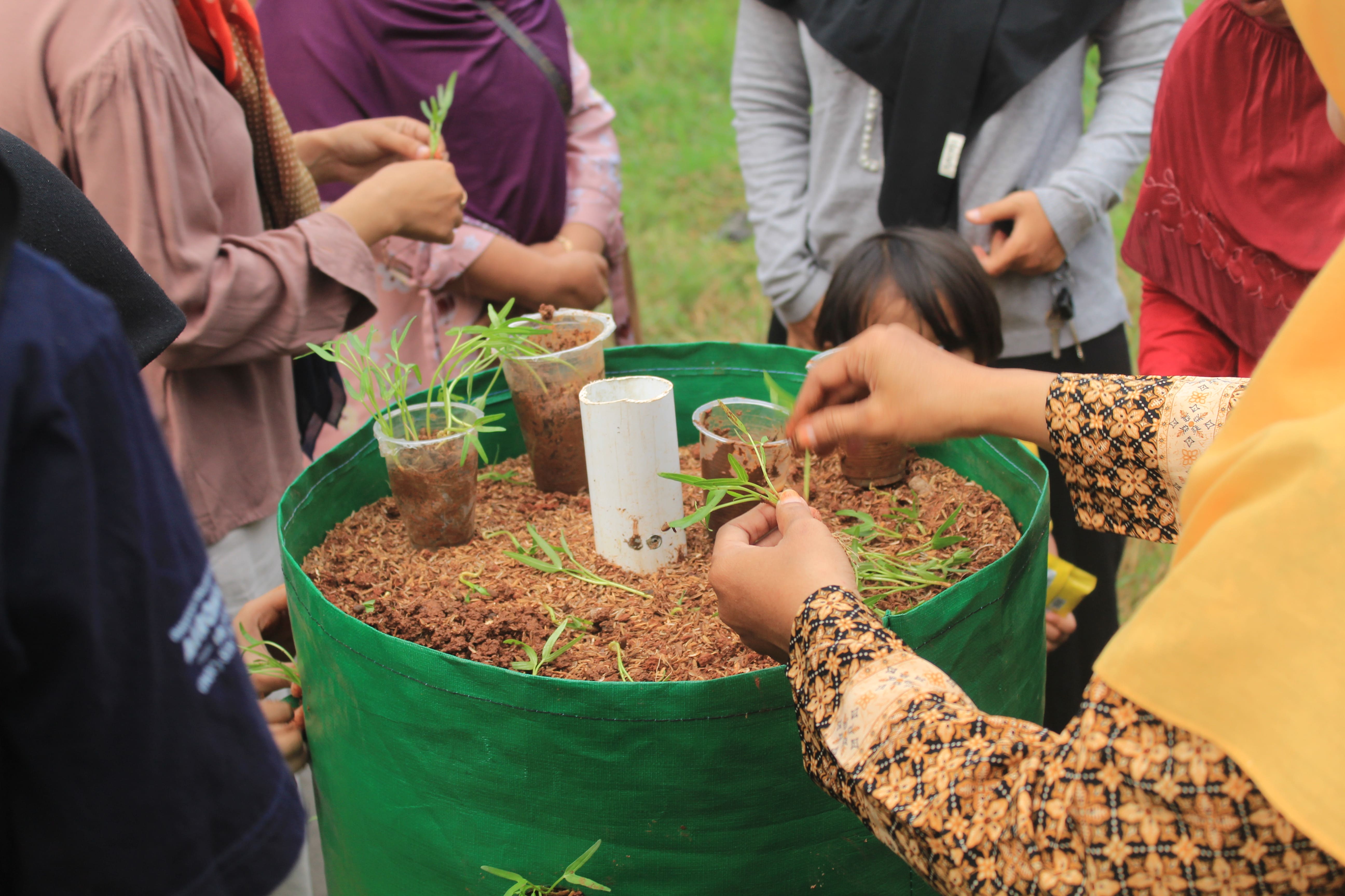 Anggota KWT Enggal Mentes antusias dalam pembuatan gardern tower bersama Tim KKN-T IPB