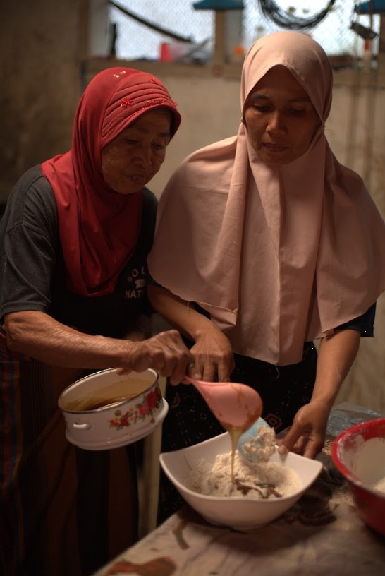 eorang ibu dan putrinya menyiapkan adonan Bareh Randang, mencampur beras sangrai dengan larutan gula dan santan di dapur keluarga. Foto oleh Rekam Indonesia/GNFI.