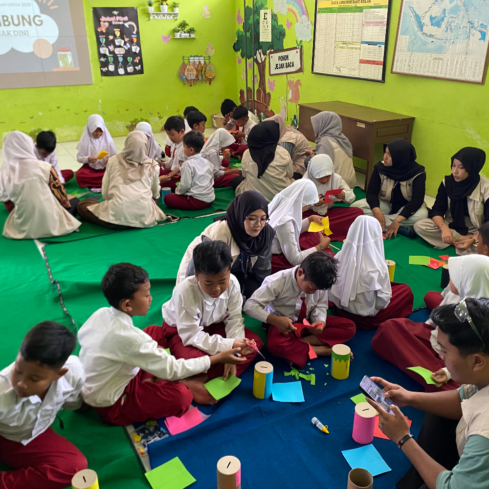 Siswa SD Negeri Plaosan 3 dengan antusias menghias Tabungan Cerdas menggunakan kertas origami dan spidol dalam kegiatan Program GEMBUNG (Gemar Menabung Sejak Dini) yang diselenggarakan oleh mahasiswa KKNT UNESA.