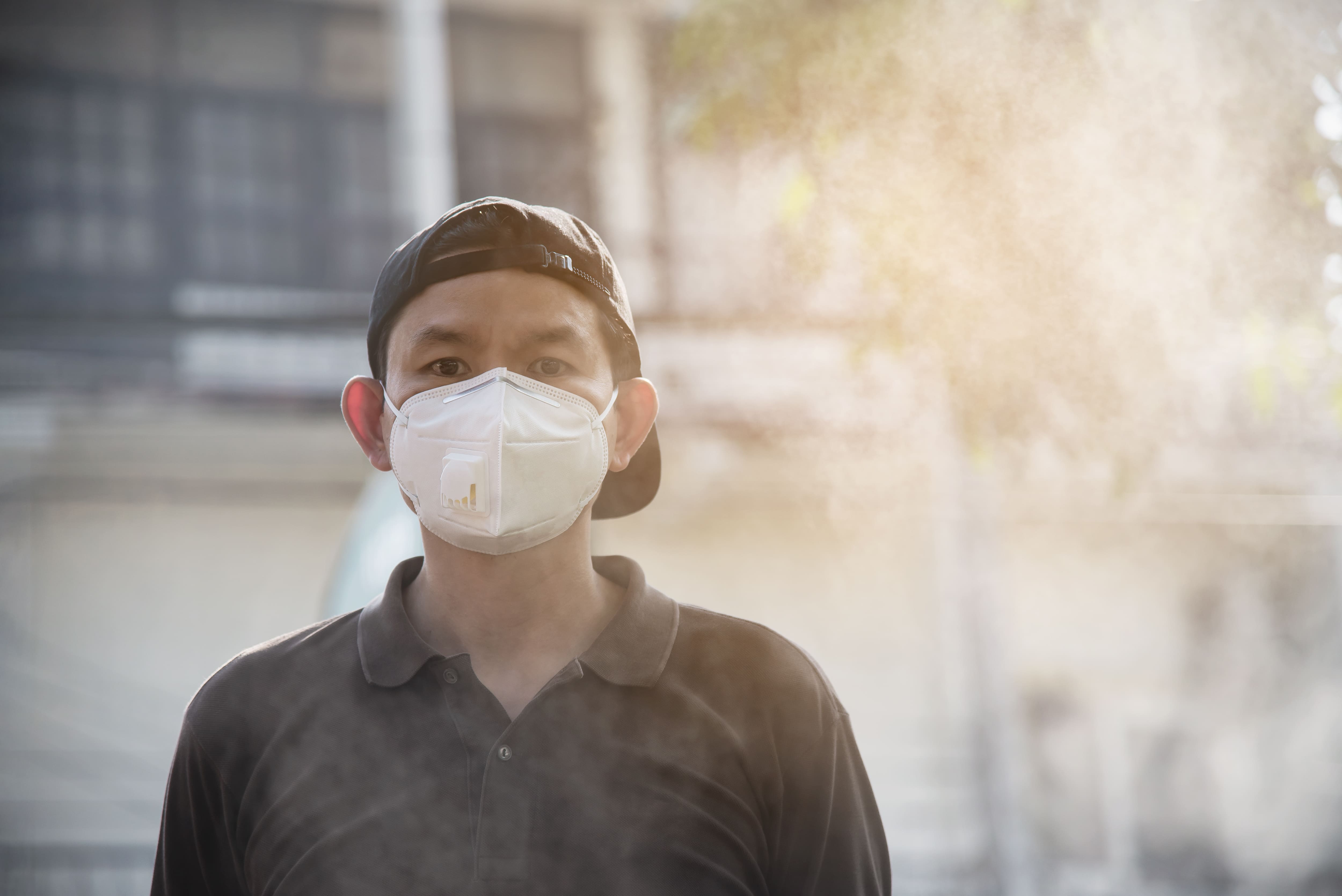 Seorang laki-laki menggunakan masker untuk menghalau polusi