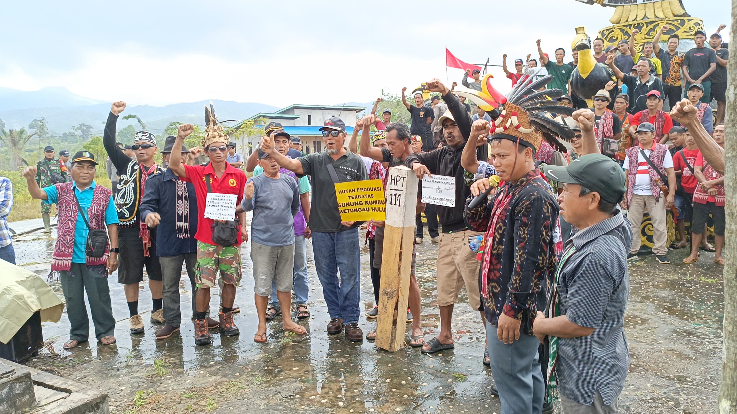 Masyarakat adat Dayak Bugau tetap berdiri teguh di bawah rintik hujan saat menyuarakan penolakan terhadap patok kawasan HPT | Dokumentasi Pribadi