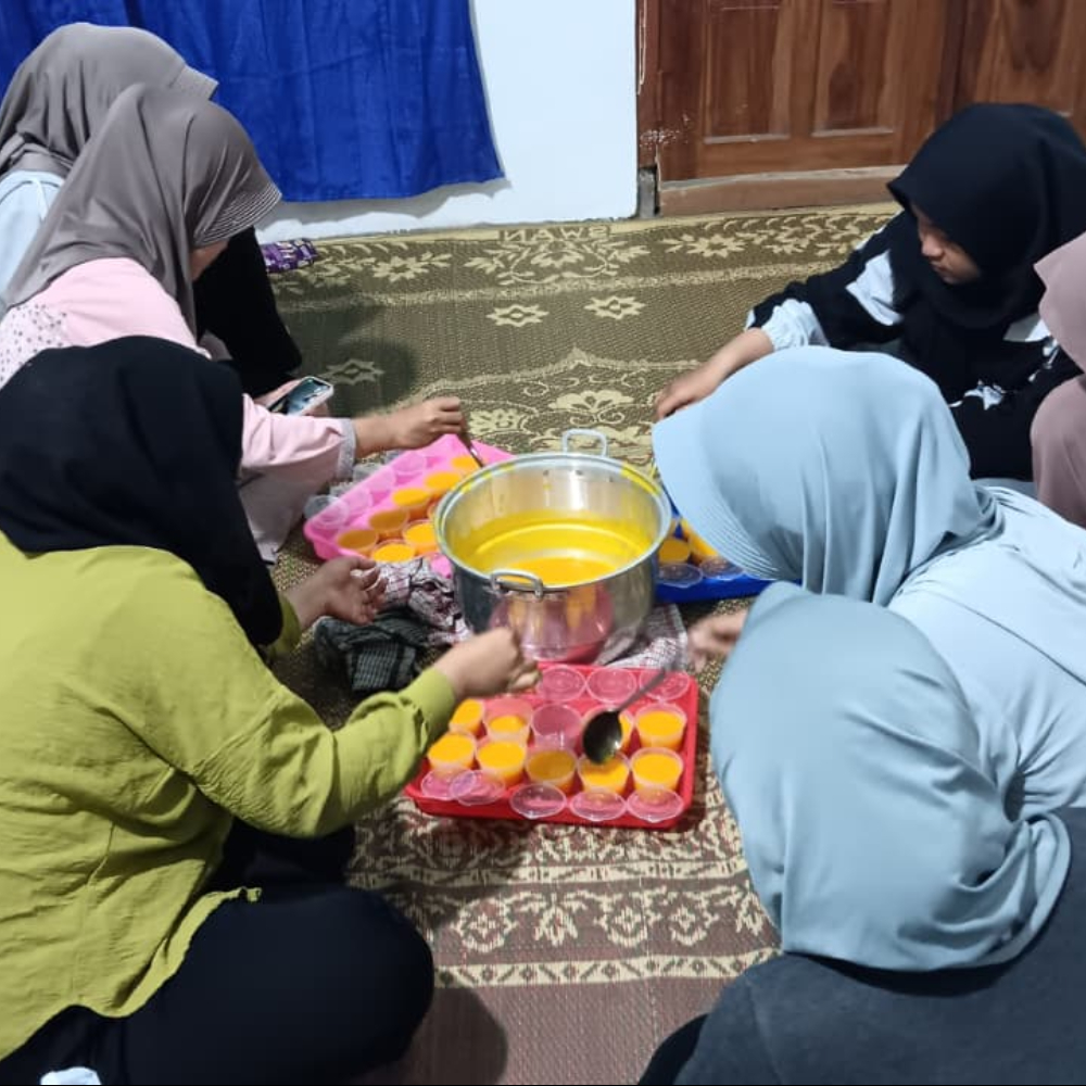 Proses pembuatan pudding labu kabocha berlangsung hangat saat mahasiswa KKN-T UNESA dan Karang Taruna RT 30–31 menuang adonan ke cetakan