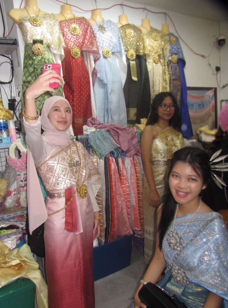Rara dan teman-temannya mencoba pakaian khas Thailand.