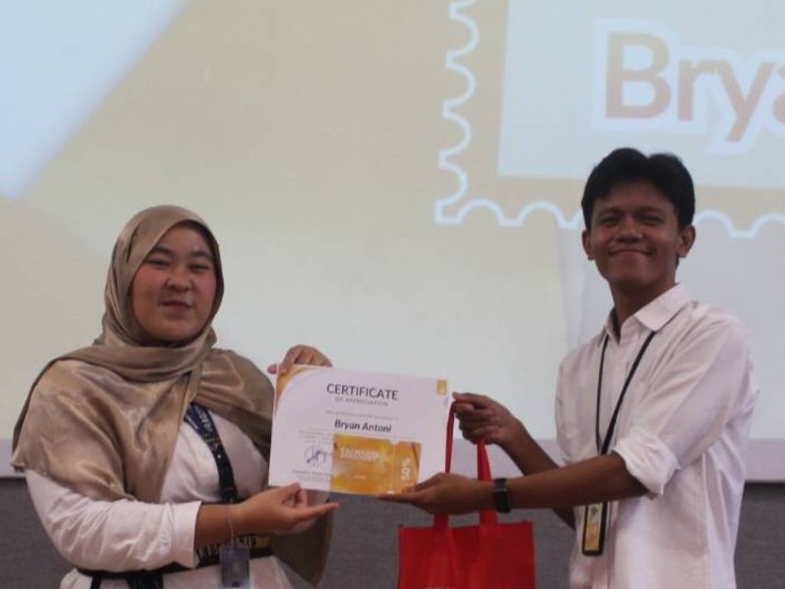 Maratul Rizki (LCVP of Engagement with AIESEC) memberikan sertifikat penghargaan kepada Bryan Antoni sebagai best delegates