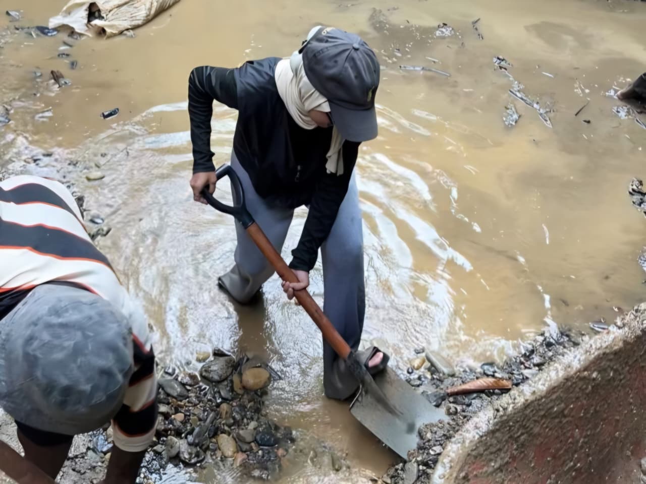 Tim Patriot UI sedang mengeruk sedimen pasir yang mengendap di penampungan air Kampung Werianggi | Dokumentasi Pribadi
