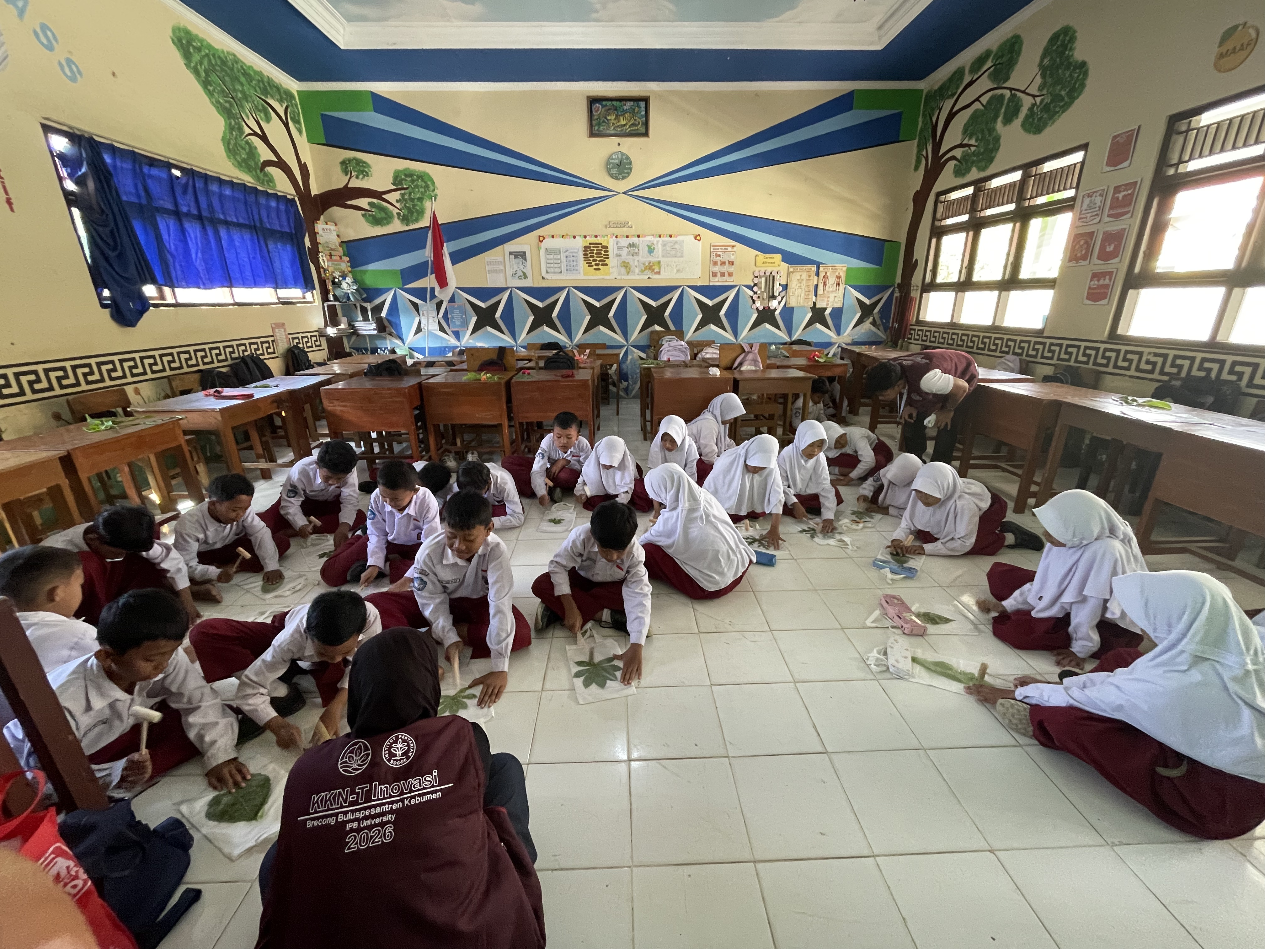 Siswa kelas V dan VI SD Negeri Brecong mempraktikkan teknik ecoprint dengan menata daun dan bunga alami di atas totebag masing-masing.
