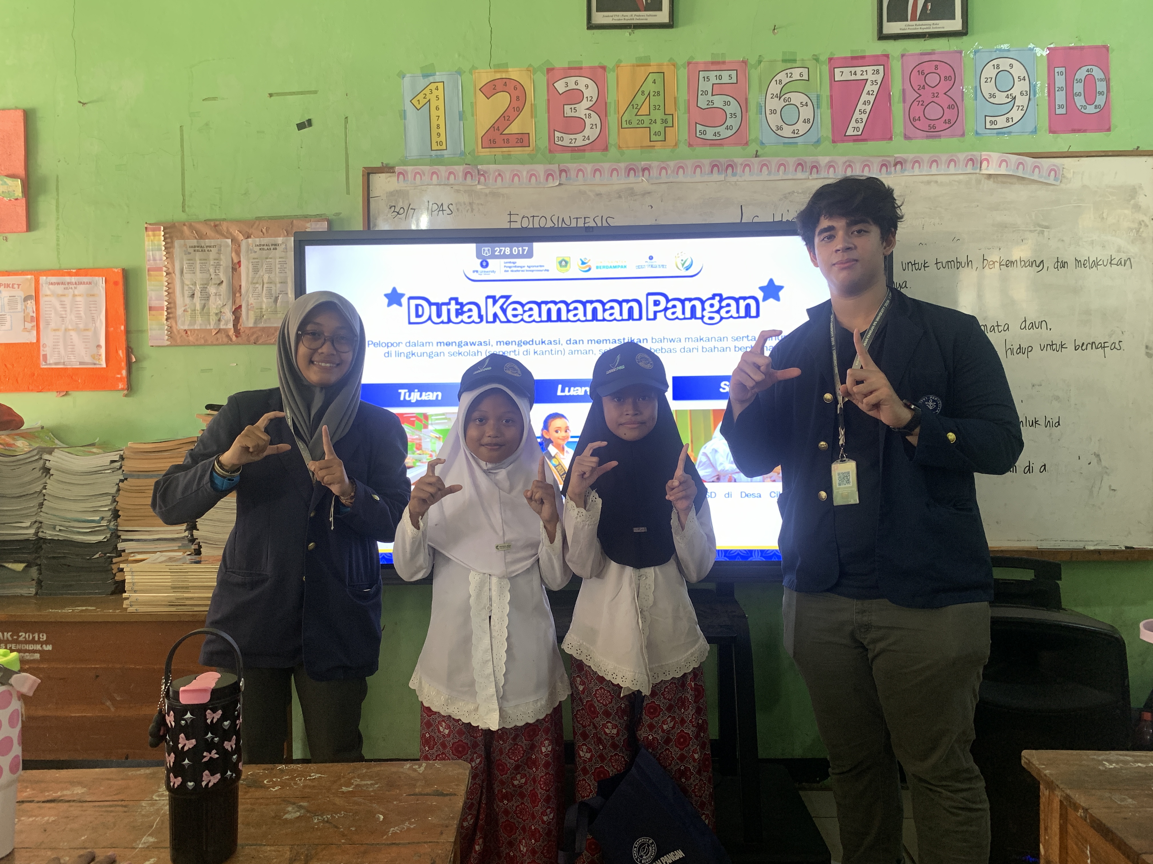 Mahasiswa KKNT Keamanan Pangan IPB University 2026 bersama siswa SDN Cihideung Udik 1 dalam kegiatan edukasi dan pemilihan Duta Keamanan Pangan sebagai upaya menanamkan kesadaran pangan aman sejak dini.
