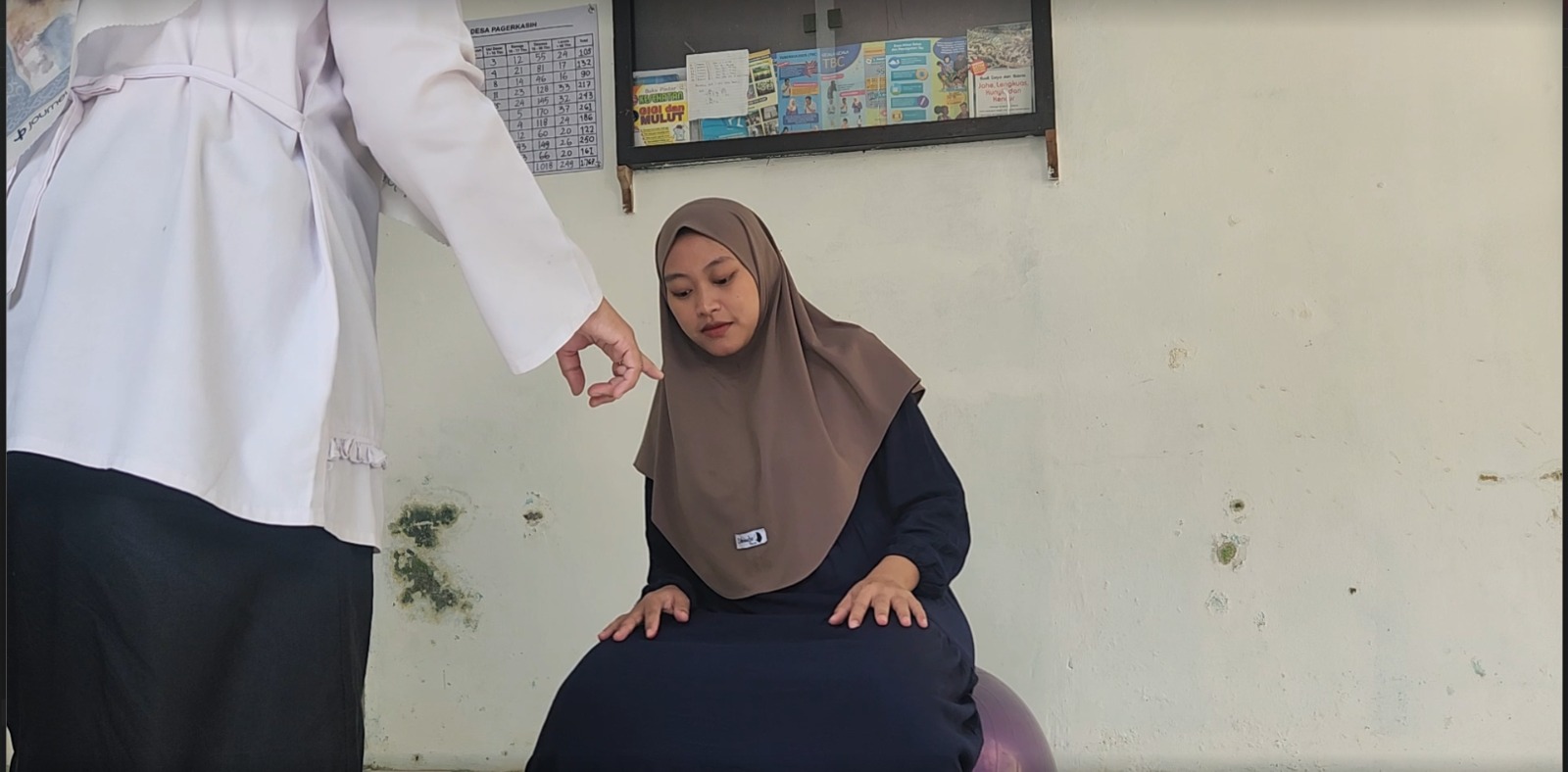 Seorang ibu hamil sedang didampingi saat mempraktikkan penggunaan bola yoga dalam program SIBOLGA Desa Pagerkasih. | Foto: Dokumentasi Pribadi