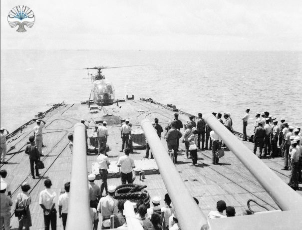 Dek haluan KRI Irian dengan tiga meriam 152 mm terlihat dari belakang, saat helikopter mendekat untuk mendarat. Foto: Perpustakaan Nasional RI, domain publik/Wikimedia Commons.