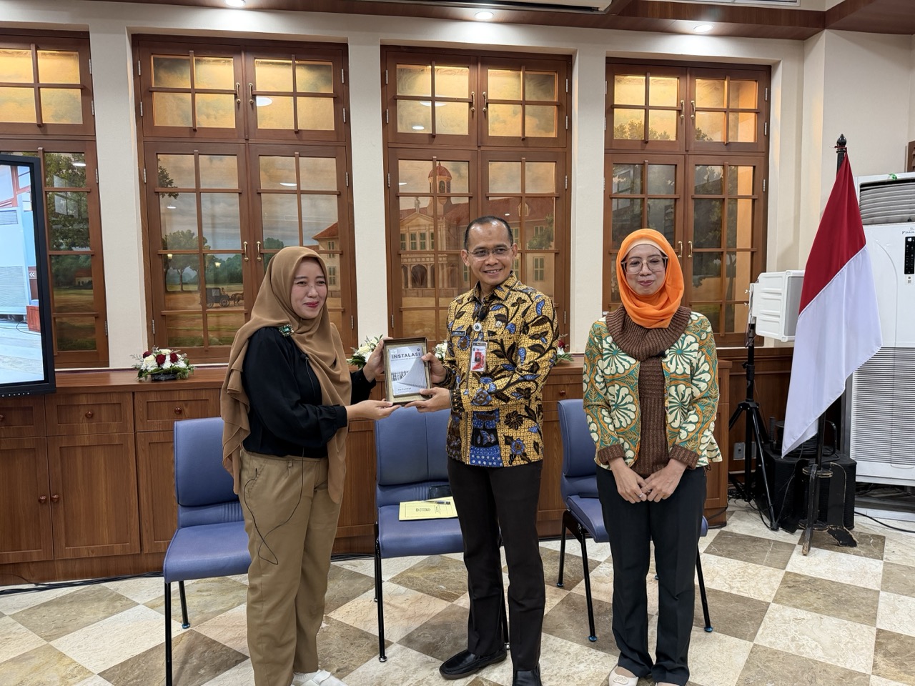 Nofa Farida Lestari, Director of Musee ID, presents a commemorative book to Mochamad Miftahulloh Tamary, Head of the Jakarta Provincial Culture Office, in appreciation of the Jakarta Provincial Government's support for hosting the ICOM CECA Annual Conference 2026.