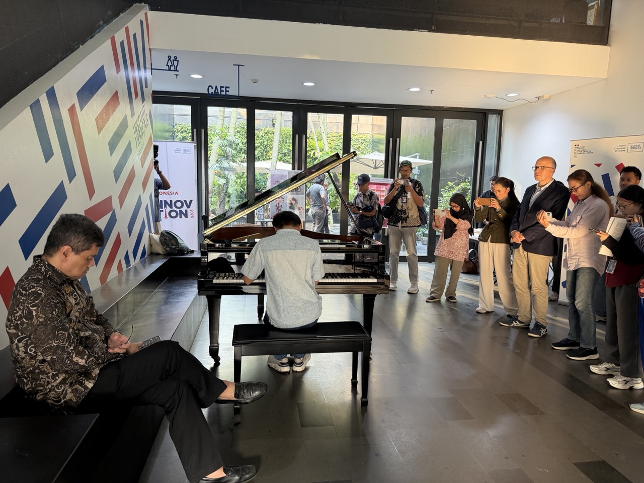 Pianist Michael Anthony Kwok performs a mini-concert at IFI Jakarta following a roundtable discussion with journalists, as Ananda Sukarlan and IFI Director Jules Irrmann look on (Seasia/Reiza)