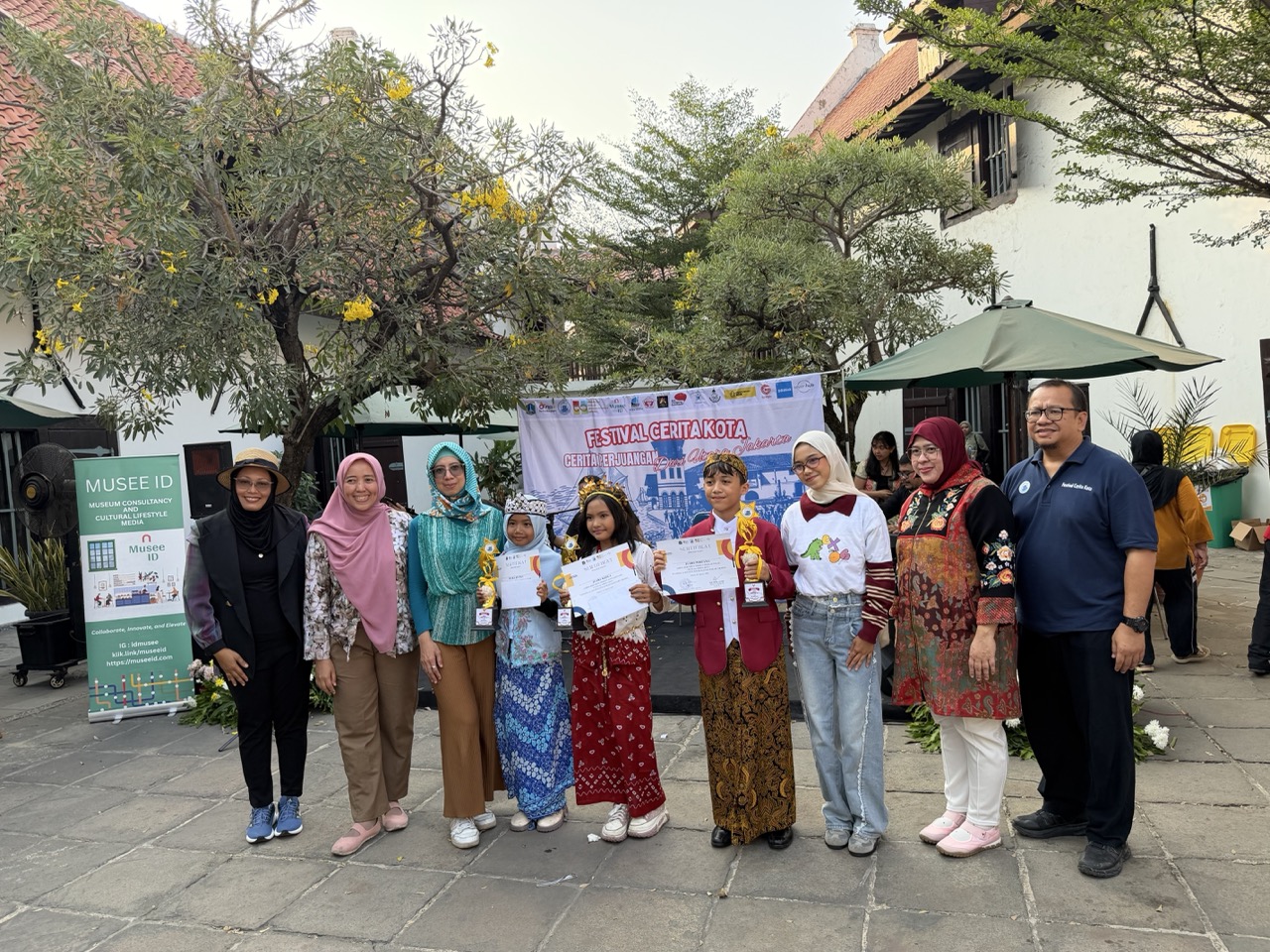 Storytelling competition winners pose with the organizers and judges after receiving cash prizes, trophies and certificates