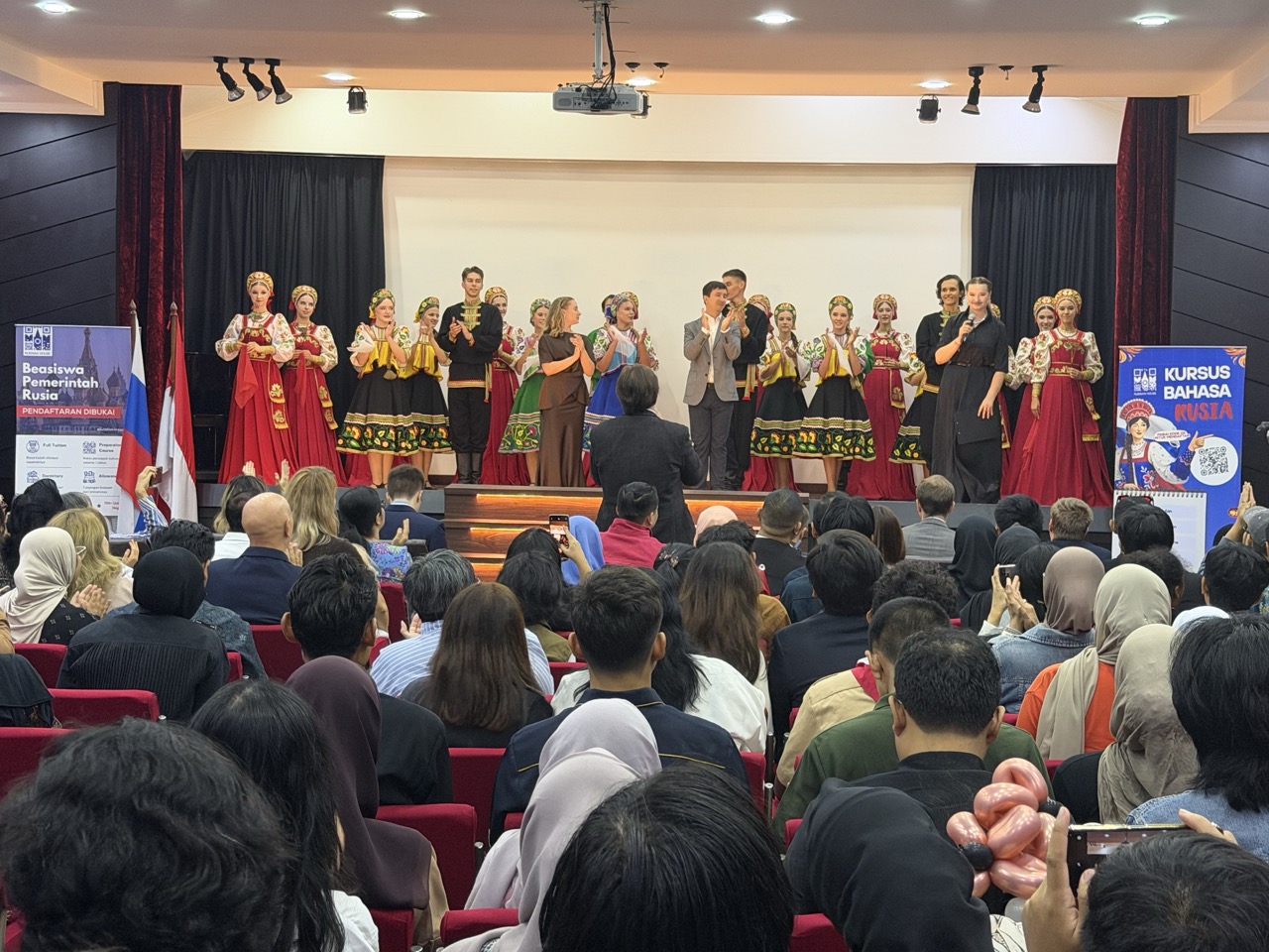 A Siberian Patterns representative joins the dancers on stage after their performance.