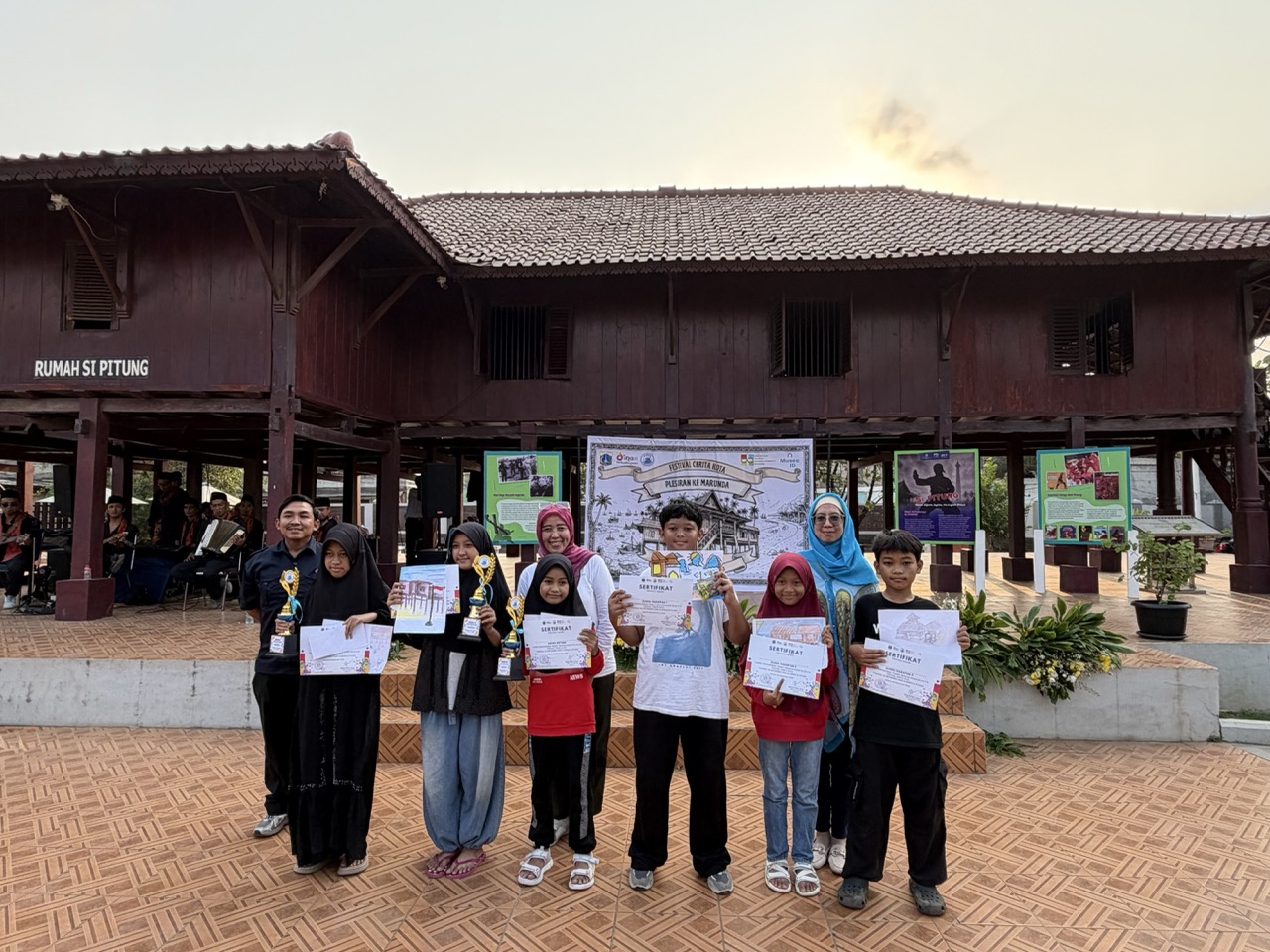 Young drawing competition winners proudly displayed their artwork, certificates and trophies at Rumah Si Pitung