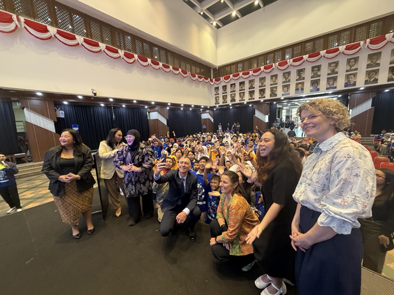German Ambassador Ralf Beste takes a selfie with students at the opening of Science Film Festival 2026 in Jakarta.