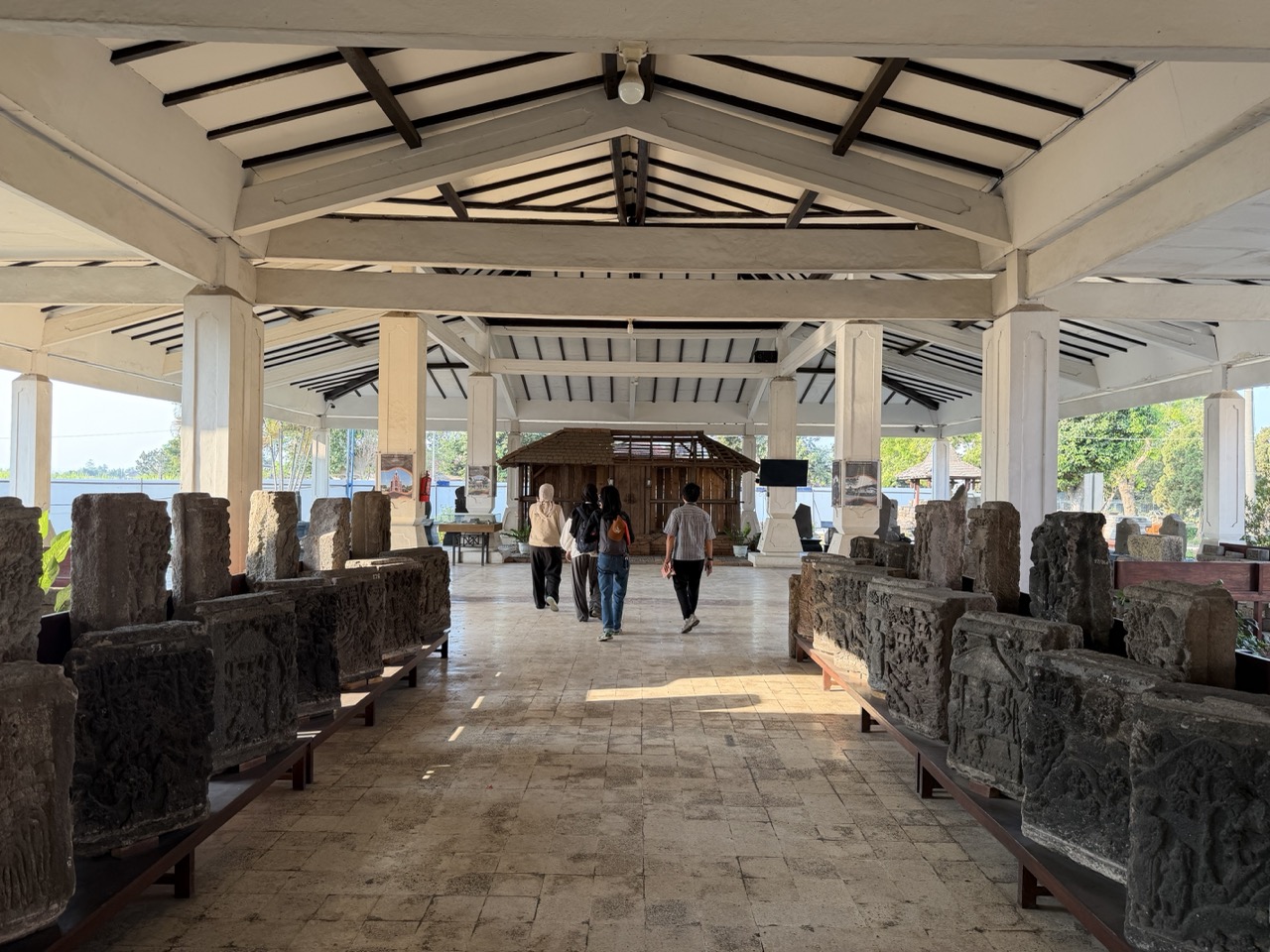 The MuseeID team walks towards a replica of a Majapahit-era house at Museum Majapahit in Trowulan, East Java.