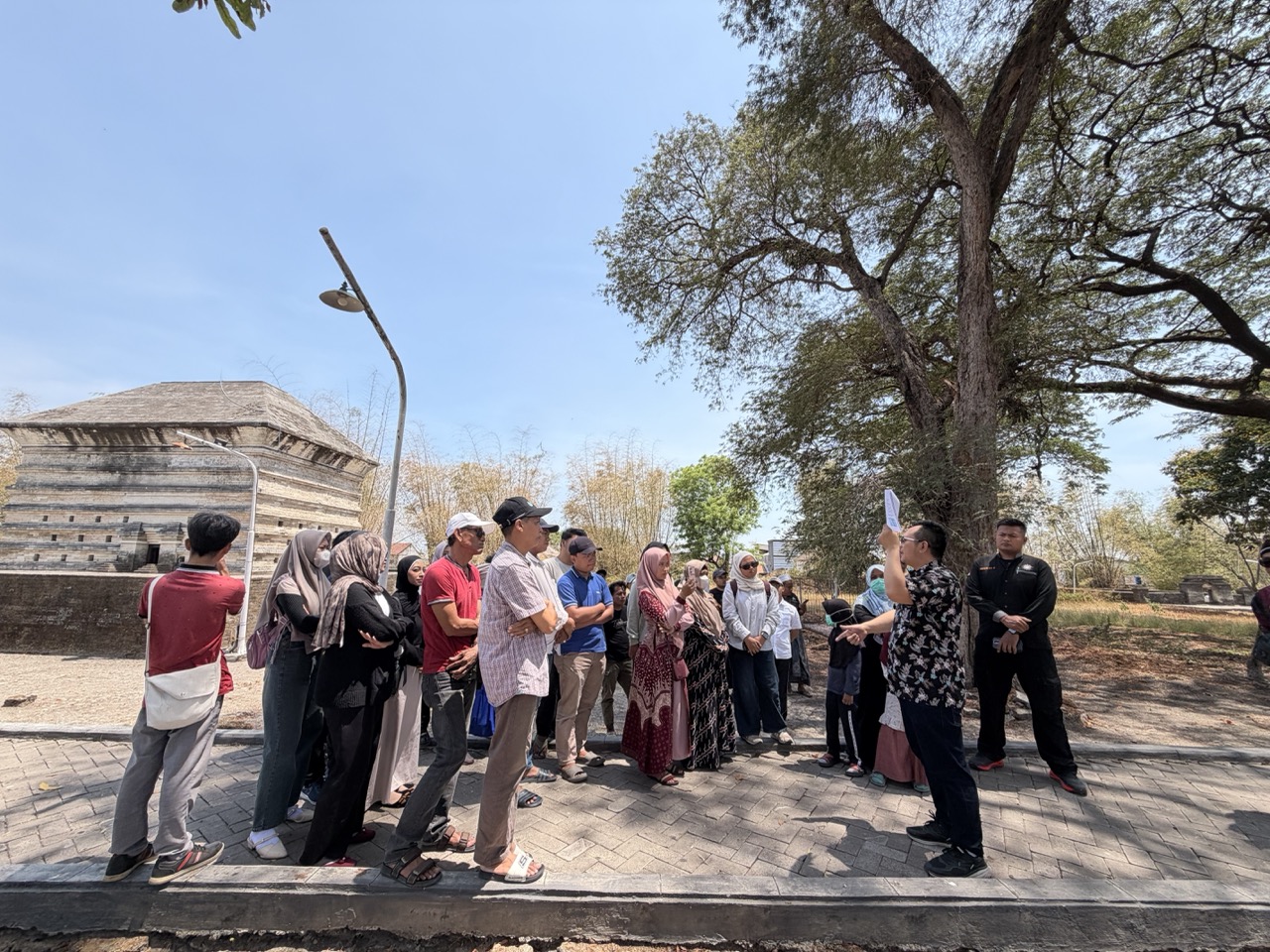 MuseeID’s Ary Sulistyo leads participants through Leran’s historic cemetery during the One Community Camp walking tour in Gresik.