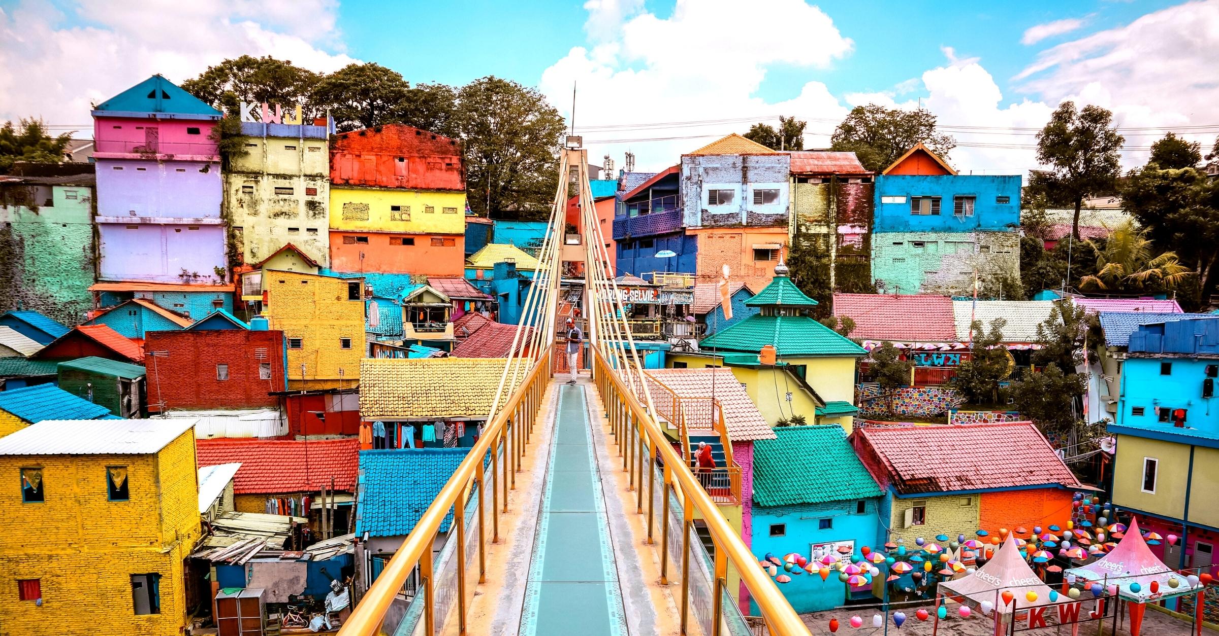 Colorful houses and pedestrian glass bridge in Kampung Warna-Warni Jodipan, a popular tourist attraction in Malang, Indonesia.