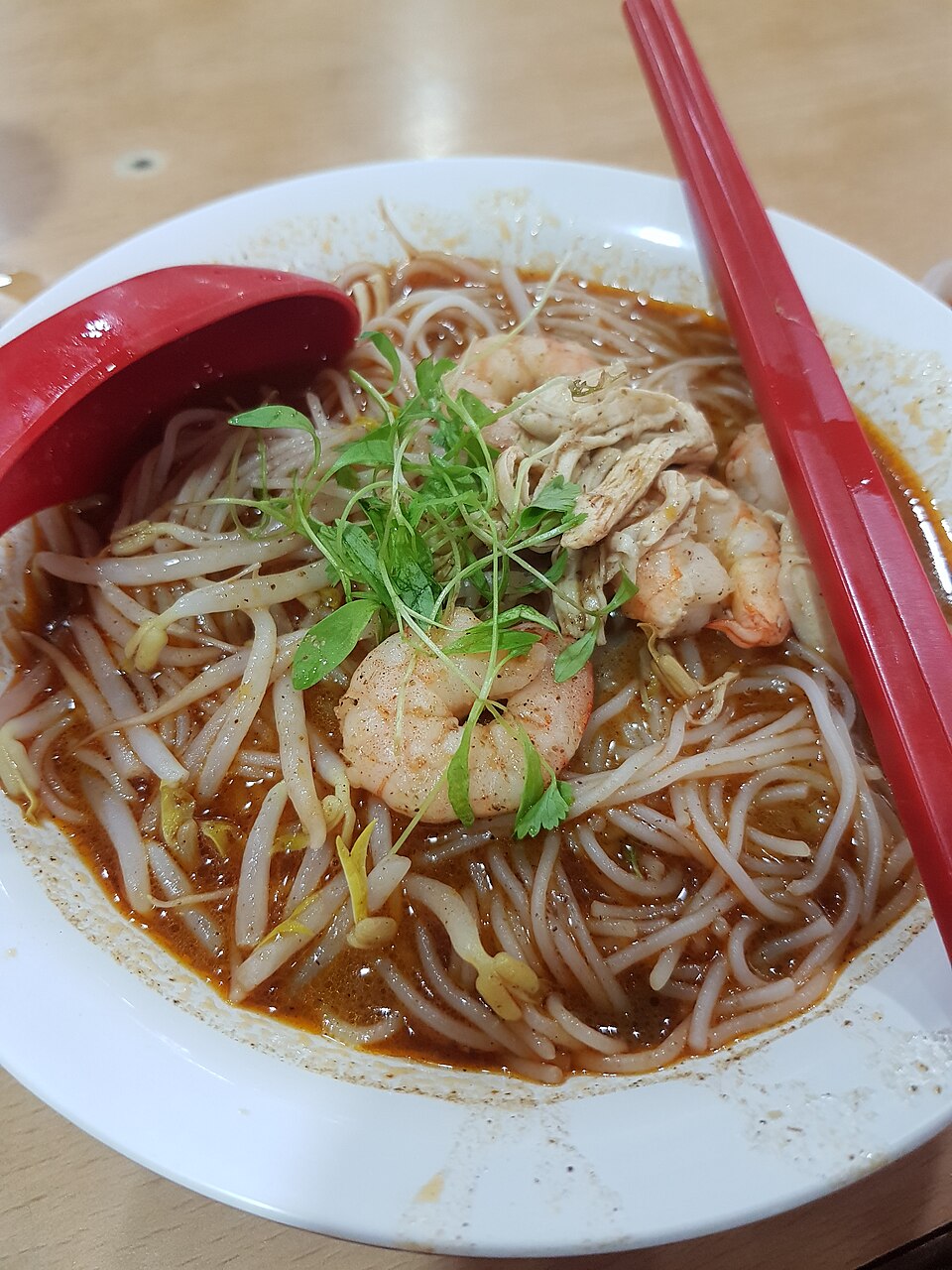 Laksa sarawak is defined by its rich and aromatic broth, created from a blend of coconut cream, prawns, shrimp paste, galangal, lemongrass, and a mix of dried spices with distinct aromas and flavors | image by Wikimedia Commons